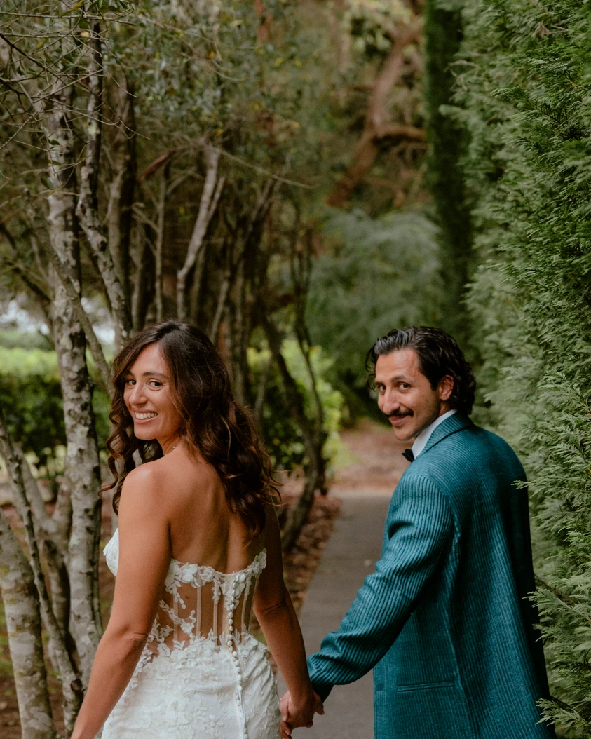 Couple walking hand in hand through trees